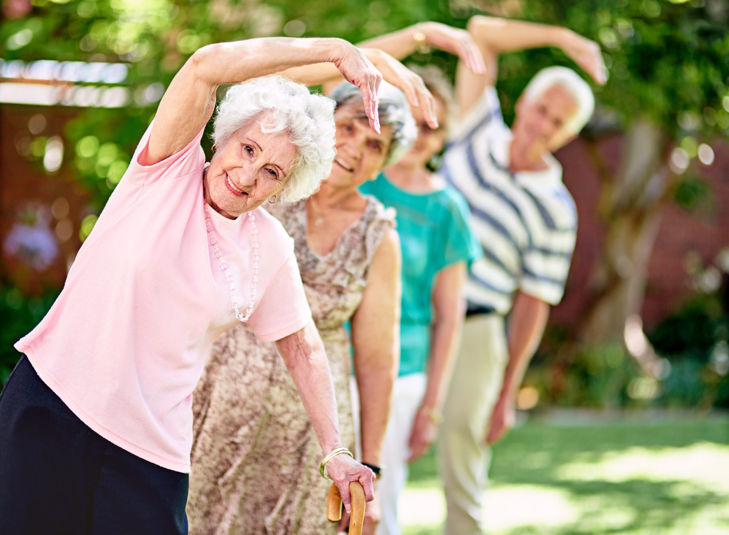 Shot of a group of smiling seniors exercising outside.
